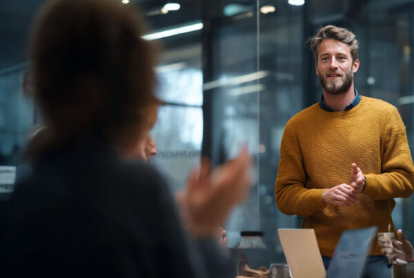 Man giving a presentation to colleagues in a modern office space